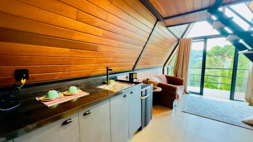 a kitchen with a sink and a large window at Chalé Das Flores in Teresópolis