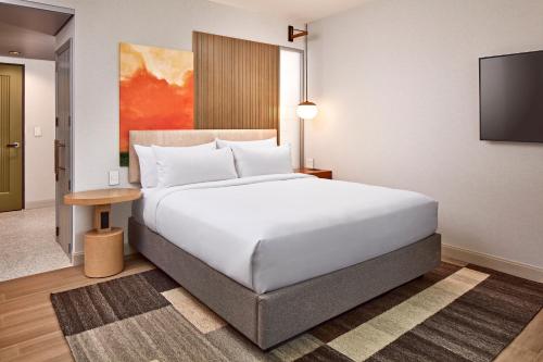 a bedroom with a large white bed and a flat screen tv at Hotel Citrine, Palo Alto, a Tribute Portfolio Hotel in Palo Alto