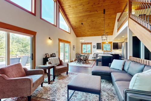 a living room with couches and a dining room at Ferncrest Mountain House in Conway