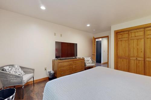 a bedroom with a bed and a flat screen tv at Ferncrest Mountain House in Conway