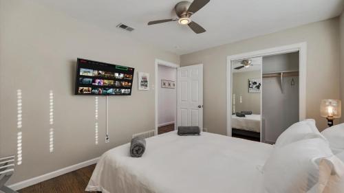 a bedroom with a white bed and a ceiling fan at Elegant 5BR 2,5BA Holiday Home with Pool, Jacuzzi, BBQ, and Cinema Room in Farmers Branch