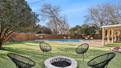 a yard with chairs and a fire pit in the grass at Elegant 5BR 2,5BA Holiday Home with Pool, Jacuzzi, BBQ, and Cinema Room in Farmers Branch