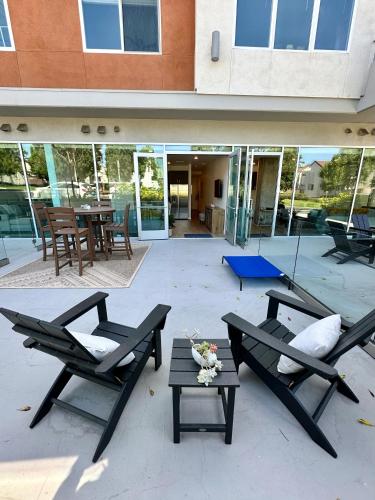 a patio with two chairs and a table and a building at Nimitz Crossing Luxury Residences in San Diego