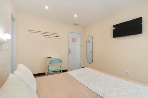 a bedroom with a bed and a tv on the wall at Hostal Art Madrid in Madrid