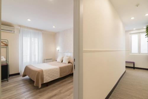 a bedroom with a bed and a large window at Hostal Art Madrid in Madrid