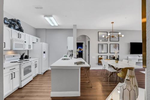 a kitchen with white appliances and a dining room at 3Bd/2Ba Elegant Condo with Resort Access in Orlando