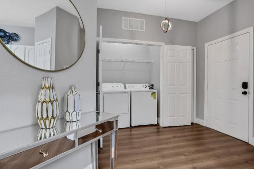 a kitchen with a refrigerator and a mirror on the wall at 3Bd/2Ba Elegant Condo with Resort Access in Orlando
