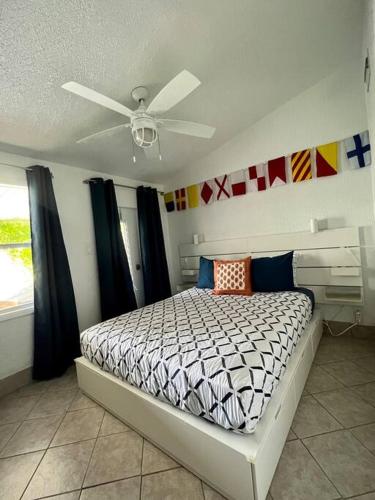 a bedroom with a bed with a ceiling fan at Blue Ocean Bungalow in Marathon