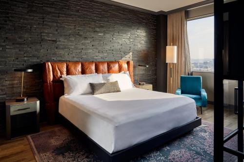 a bedroom with a large bed and a brick wall at Loews Nashville Hotel at Vanderbilt Plaza in Nashville