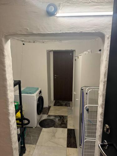 Un baño con puerta y lavadora. en Eksporta Appartaments, en Riga