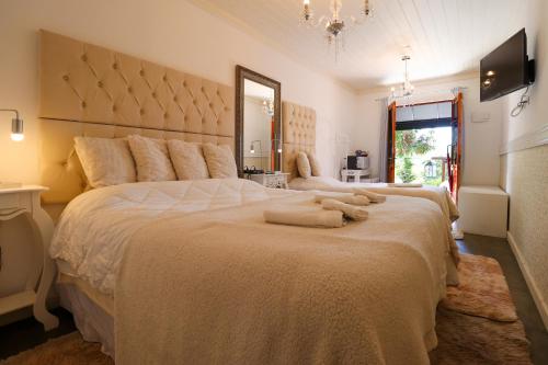 a bedroom with a large bed with towels on it at Pousada Campos do Jordao Suites in Campos do Jordão