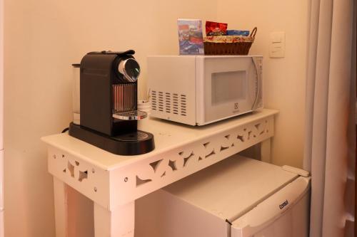 a microwave and a coffee maker on a shelf at Pousada Campos do Jordao Suites in Campos do Jordão