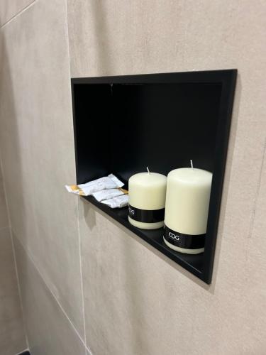 two candles on a shelf on a wall in a bathroom at Casa Lounge Costituzione in Cagliari