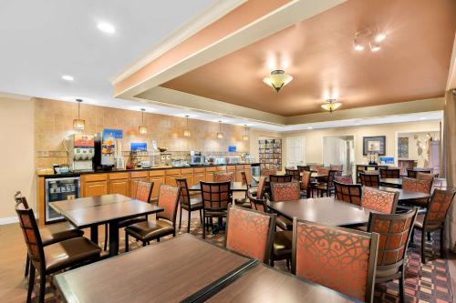 a restaurant with tables and chairs and a bar at Best Western Coach House in Springfield