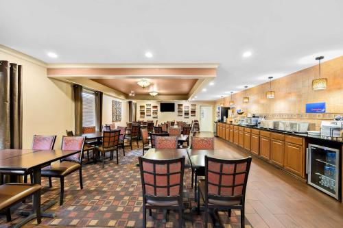 a restaurant with tables and chairs and a kitchen at Best Western Coach House in Springfield