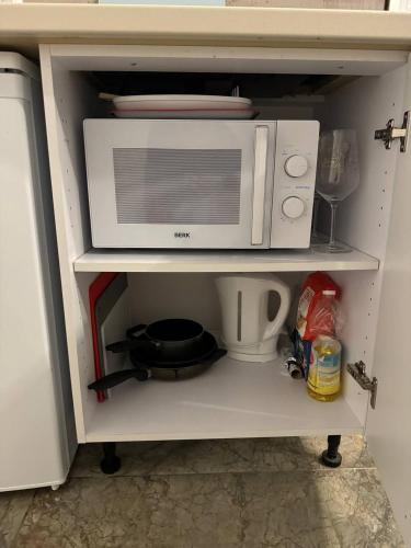 un horno microondas en la parte superior de un estante en Eksporta Appartaments, en Riga
