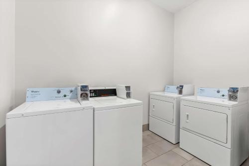 three white washers and dryers in a room at Sonesta Essential La Porte in La Porte