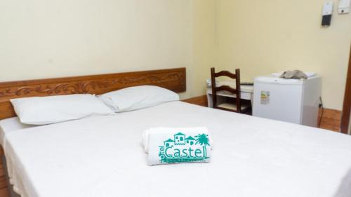a bedroom with a white bed with a sign on it at Canoas Hotel Castel in Canoas