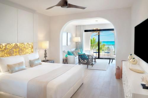 a white bedroom with a bed and a living room at Sanctuary Cap Cana, a Luxury Collection Resort, Dominican Republic, Adult All-Inclusive in Punta Cana
