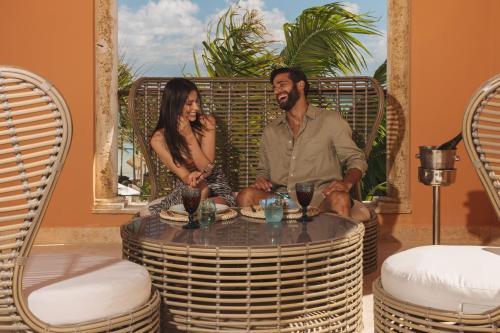 a man and a woman sitting around a table at Sanctuary Cap Cana, a Luxury Collection Resort, Dominican Republic, Adult All-Inclusive in Punta Cana