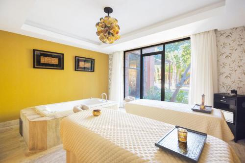 a room with two beds and a bath tub at Sanctuary Cap Cana, a Luxury Collection Resort, Dominican Republic, Adult All-Inclusive in Punta Cana