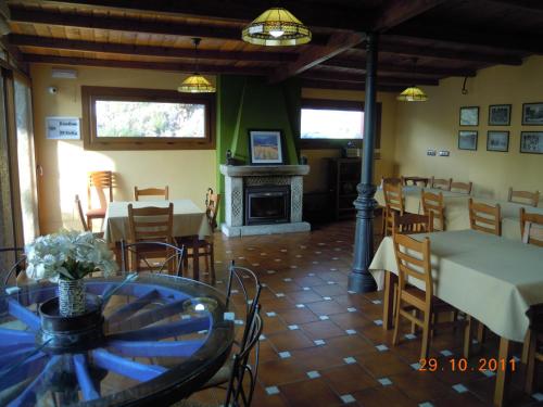 een eetkamer met tafels en stoelen en een open haard bij HOSTAL Restaurante RANCHEIRO in Vigo