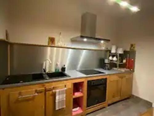 une cuisine avec un évier et une cuisinière dans l'établissement Appartements centre-ville, à Bagnères-de-Bigorre