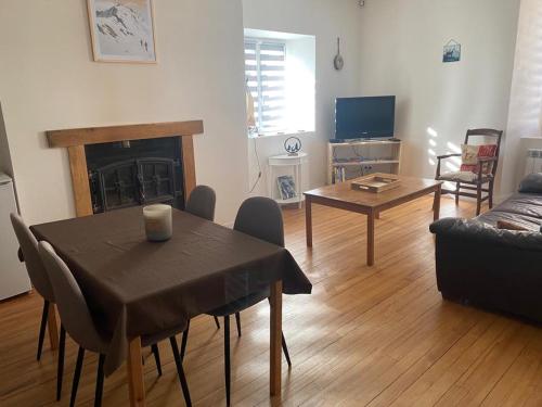 ein Wohnzimmer mit Tisch und Kamin in der Unterkunft Appartements centre-ville in Bagnères-de-Bigorre