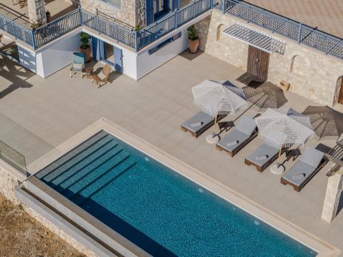 an overhead view of a swimming pool with lounge chairs and a swimming pool at Blue Sea House in Agios Nikolaos