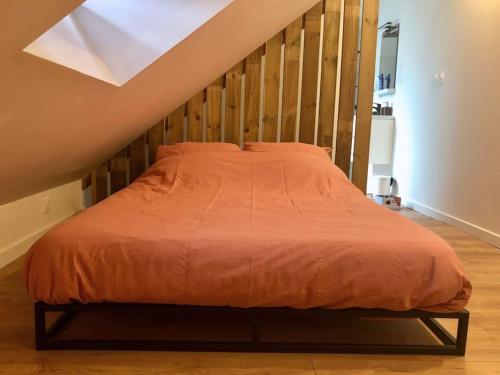 a bed with an orange comforter in a bedroom at Home Sweet Home in Loos