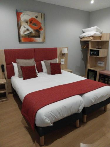 a bedroom with a large bed with a red headboard at Hotel Saint Augustin in Strasbourg