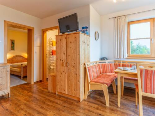 a living room with a table and a tv on a cabinet at Blick ins Brixental in Hopfgarten im Brixental