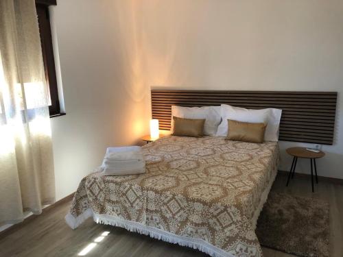 a bedroom with a bed with a blanket and pillows at Casa Rural - Quinze in Rabal