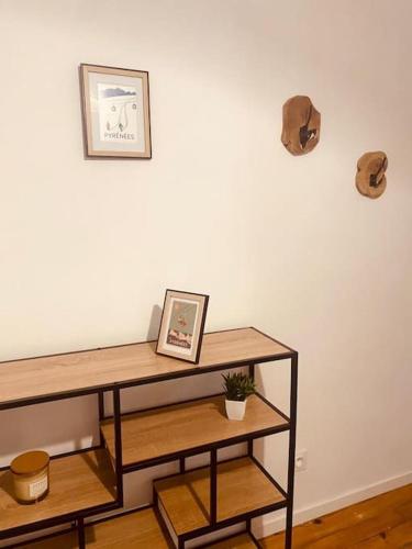 une étagère avec une photo sur un mur blanc dans l'établissement Grand Studio à 3 min du centre-ville, à Bagnères-de-Bigorre