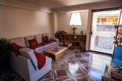 a living room with a couch and a coffee table at Peru Quechua's Lodge Ollantaytambo in Ollantaytambo
