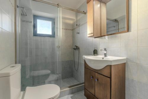 a bathroom with a toilet and a sink and a shower at Blue Sea House in Agios Nikolaos