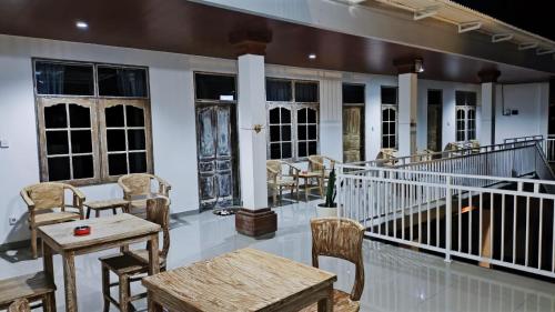 - une terrasse couverte avec des tables, des chaises et des fenêtres dans l'établissement Pulmo Residen Canggu, à Canggu