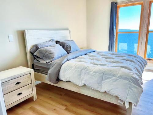 a bedroom with a large bed with a window at Luxury Bayfront Oasis with Private Beach Access, Near Tulalip Casino and Outlets! in Tulalip Bay