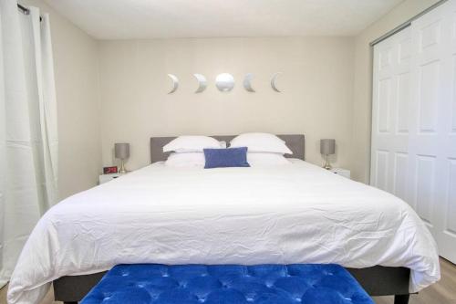 a bedroom with a large white bed with blue pillows at Modern-Sunroom-15min to DwnTwn-Grps-Kids-Firepit in Indianapolis