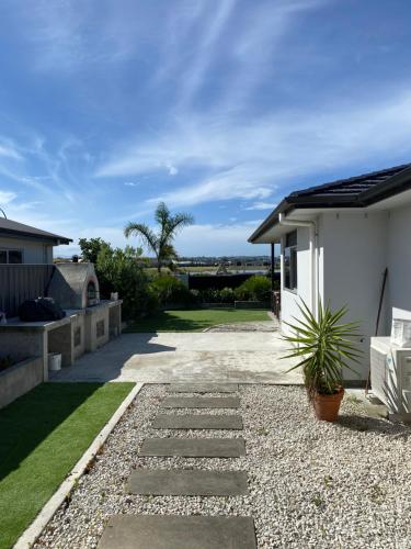 a garden with a stone walkway next to a house at Parkview Home 5min from CBD in Napier