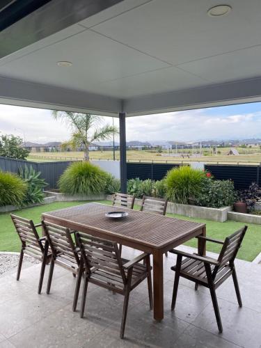 a wooden table and chairs on a patio at Parkview Home 5min from CBD in Napier