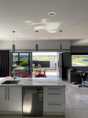 a kitchen with a sink and a living room at Parkview Home 5min from CBD in Napier