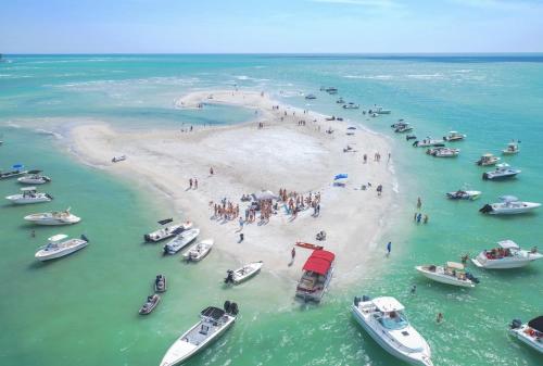 a group of people on a beach with boats at Newly remodeled 8-steps to sand path of Beach! in Siesta Key