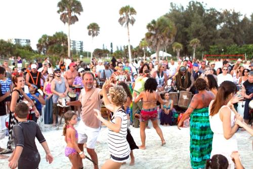 a crowd of people on a beach with people dancing at Newly remodeled 8-steps to sand path of Beach! in Siesta Key