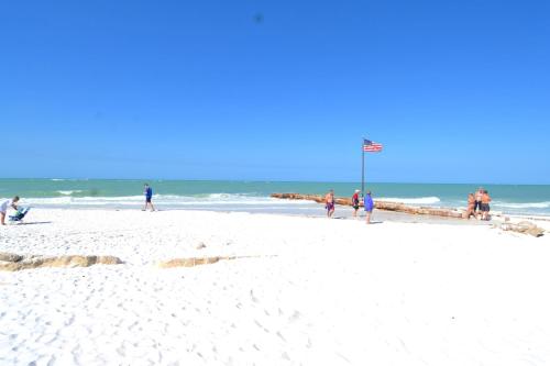 a group of people walking on the beach at Newly remodeled 8-steps to sand path of Beach! in Siesta Key