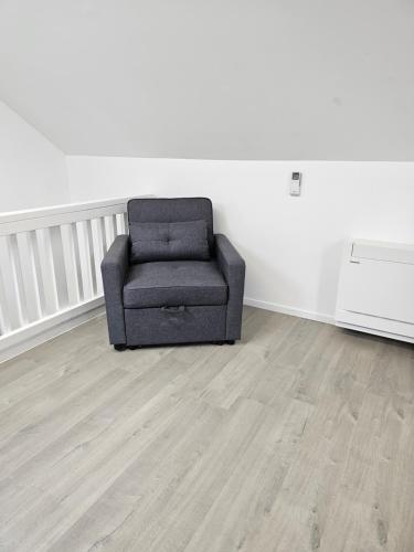 a chair sitting in an empty room next to a wall at Cottage in Puhoi