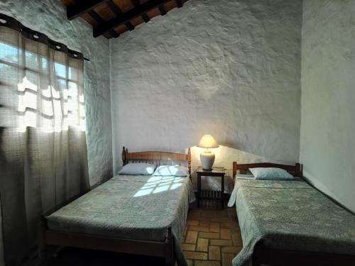 two beds in a room with a window at Hostel Ysapy en Piribebuy - Paraguay in Piribebuy
