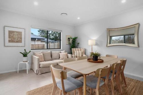 a living room with a table and a couch at Andrica House - Your Southern Highlands Retreat! in Mittagong