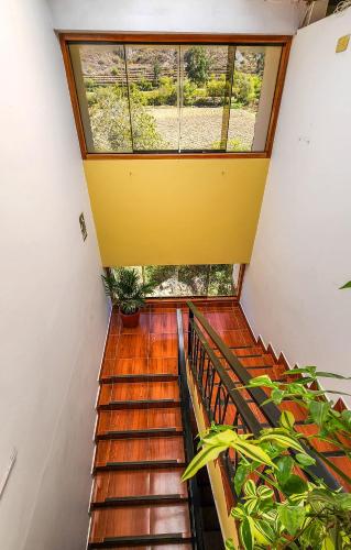 a staircase in a house with a large window at Peru Quechua's Lodge Ollantaytambo in Ollantaytambo