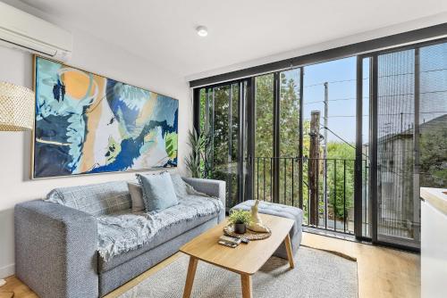 una sala de estar con un sofá y una mesa en Contemporary 1-Bed in the Heart of St Kilda, en Melbourne